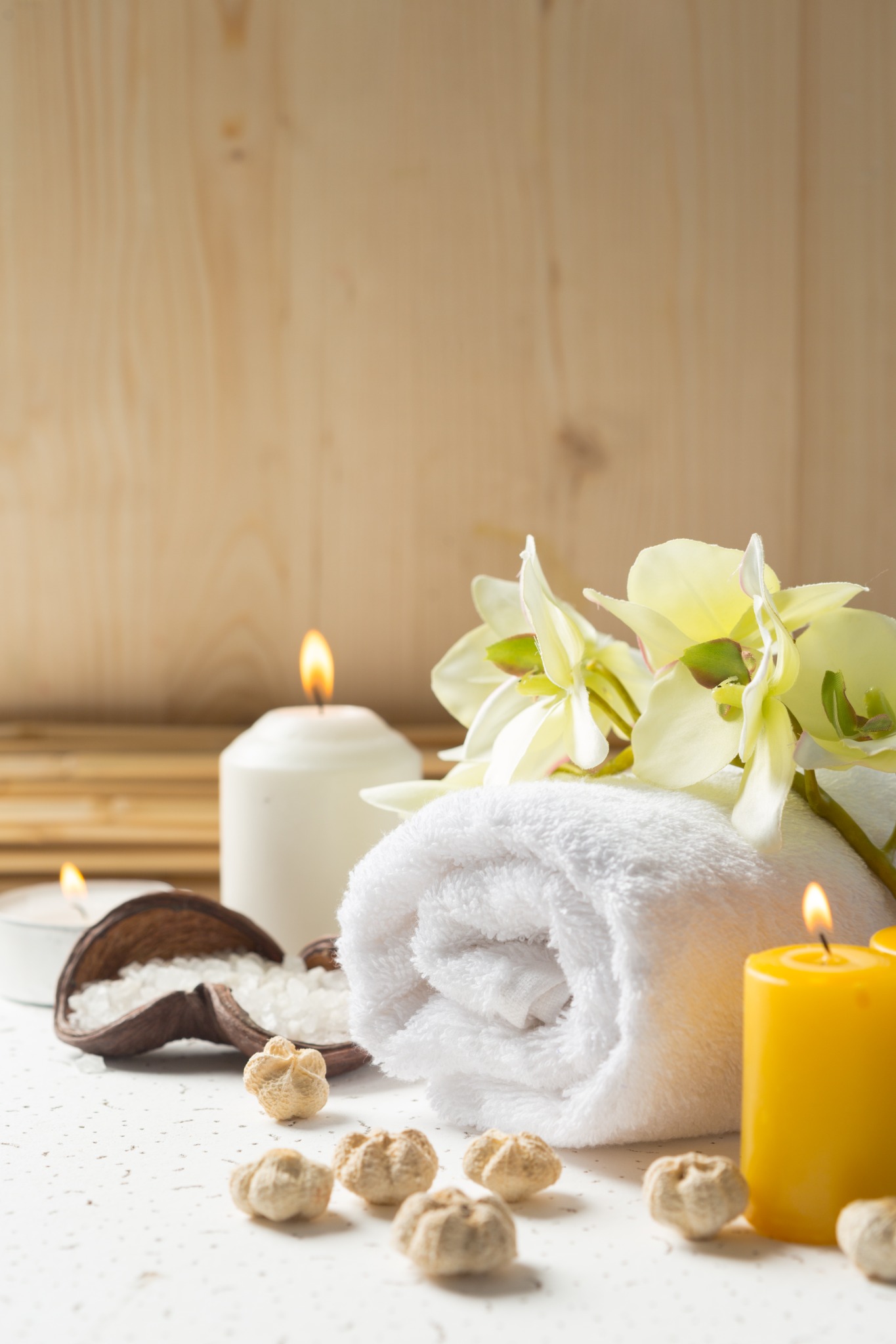 Toallas, velas y flores en un ambiente de spa